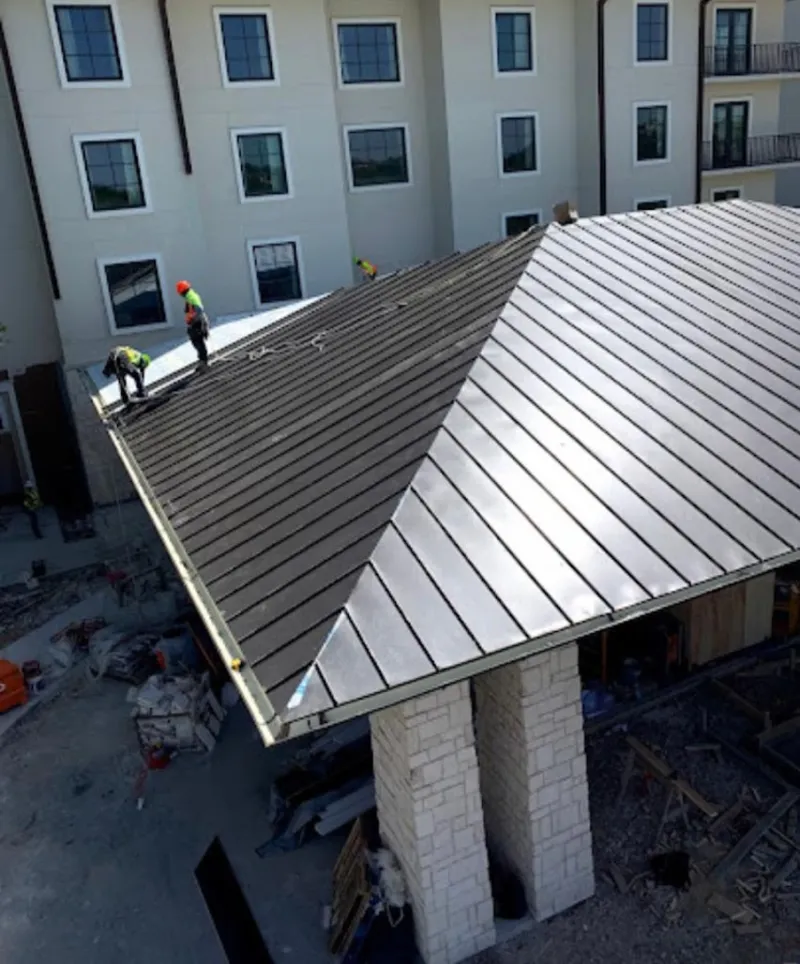Crew installing standing seam metal roof panels on a commercial project in Kissimmee